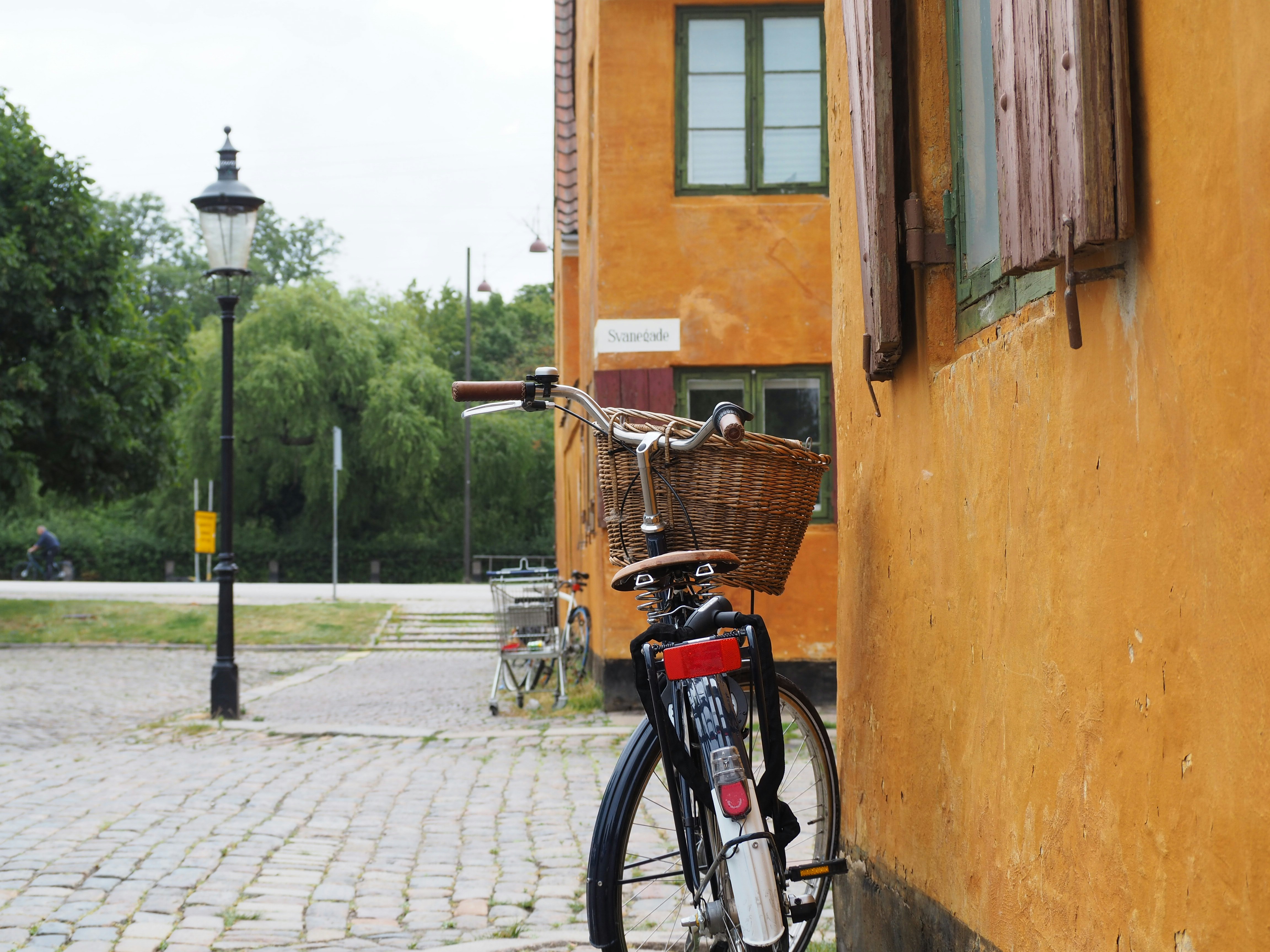 a bicycle parked next to a yellow building, 