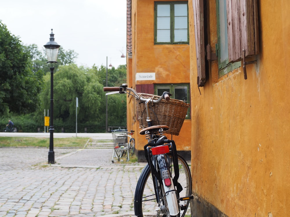 a bicycle parked next to a yellow building