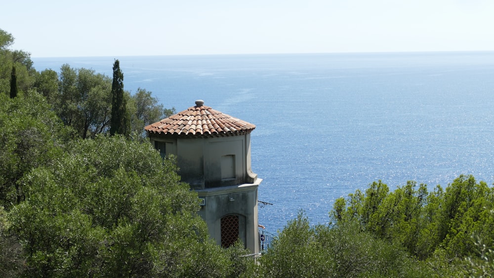a tower with a tiled roof overlooks the ocean