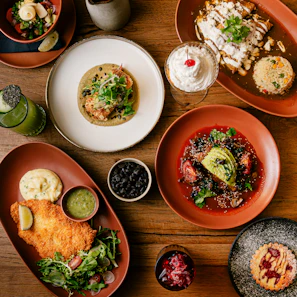 a wooden table topped with plates of food