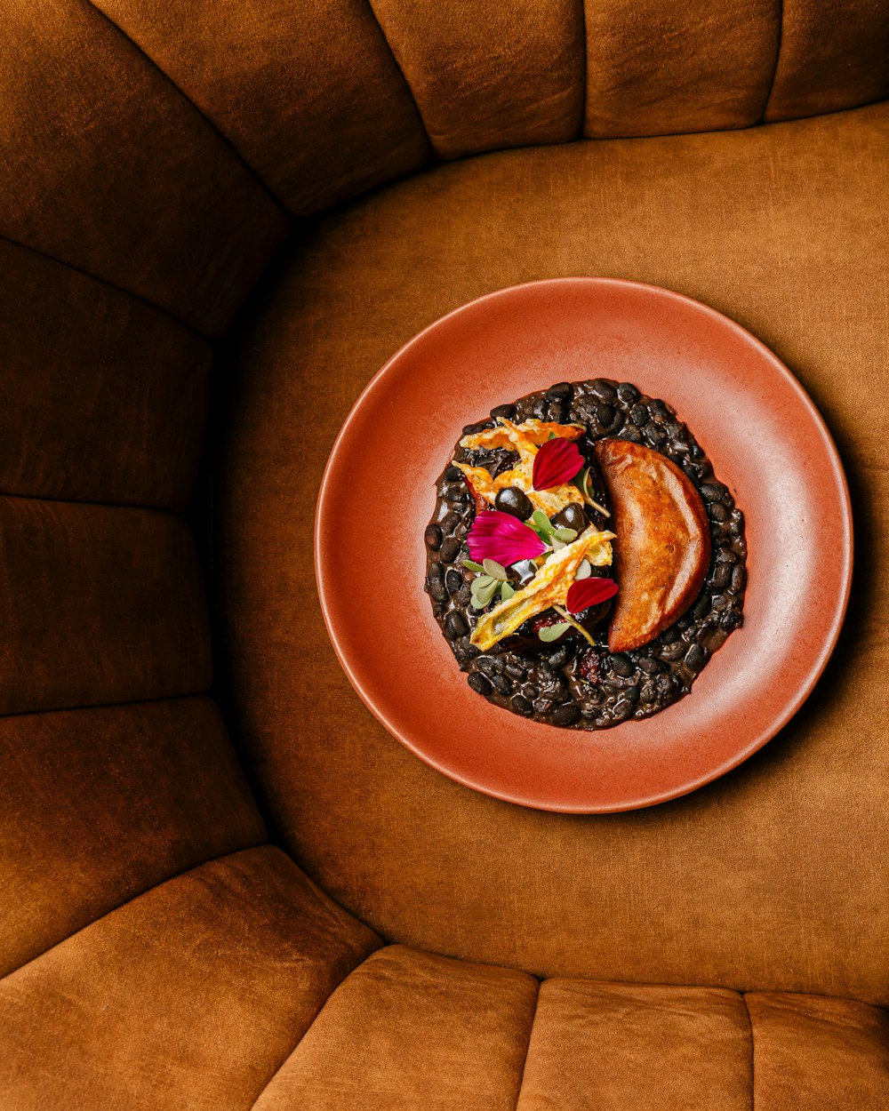 a plate of food sitting on top of a brown chair