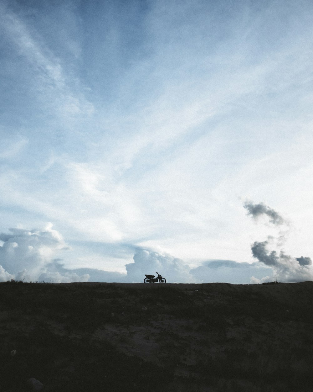 a person standing on top of a hill under a blue sky