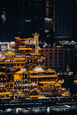 Nighttime skyline of a Chinese city illuminated with vibrant lights and skyscrapers.