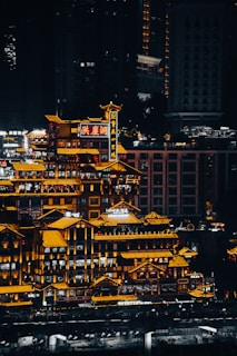 Night-time cityscape showcasing iconic buildings from both Zambia and China illuminated with their national colors