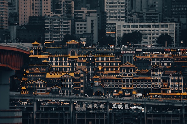 A serene image of a modern Chinese city skyline at dusk, softly illuminated with warm golden lights.