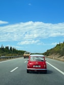 Mini 5 Door in vibrant red driving along a coastal road