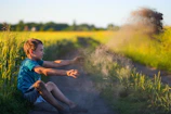 Children playing joyfully in a terracotta-colored field under soft afternoon light.