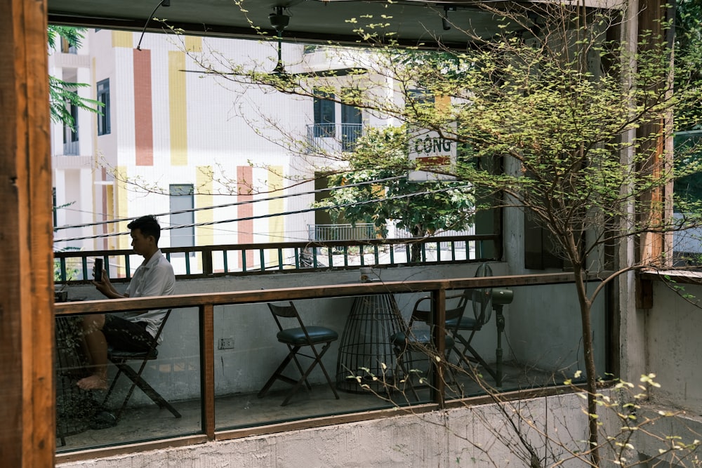a man sitting at a table on a balcony
