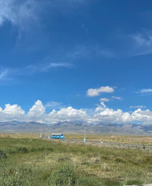 A spacious, comfortable bus driving along a scenic Indian highway under a clear blue sky.