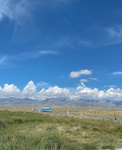 A spacious bus driving on a scenic road.