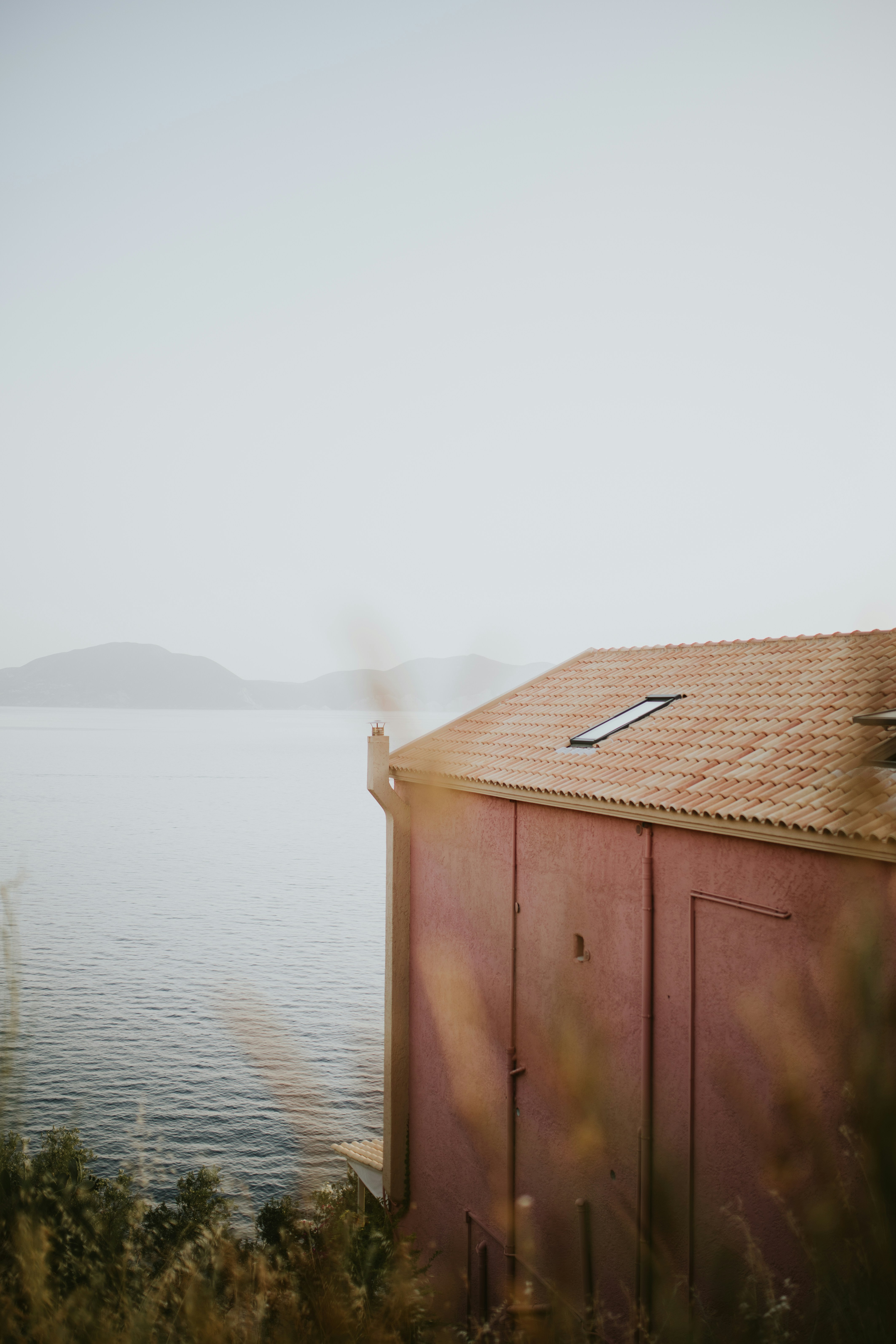 ein rotes Gebäude, das neben einem Gewässer sitzt