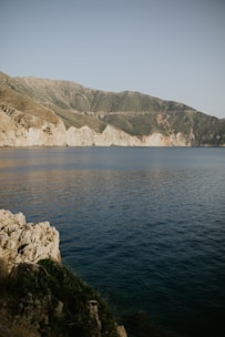 A serene coastal trail winding through rolling green hills under a soft morning light.