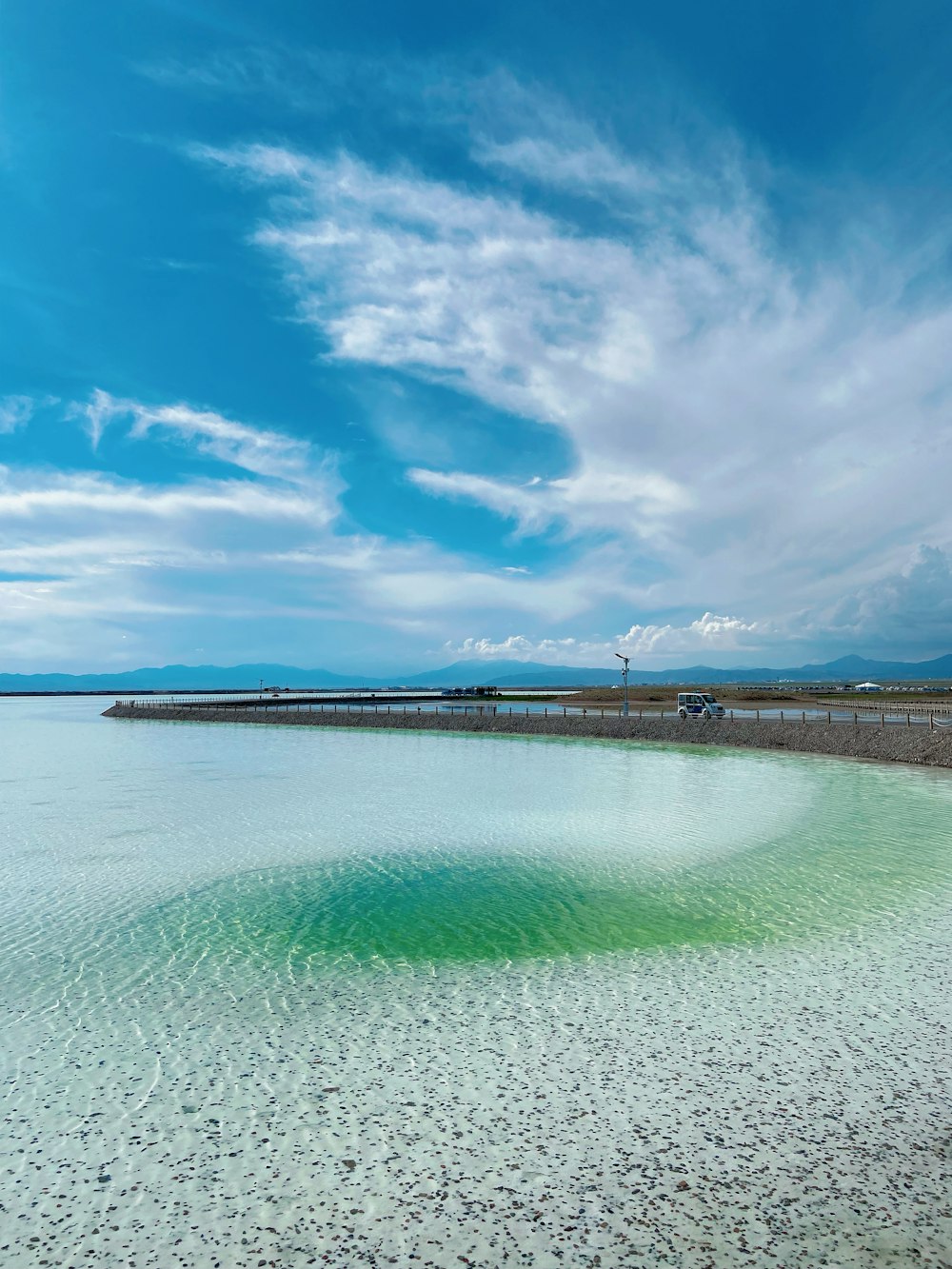 a large body of water sitting under a blue sky