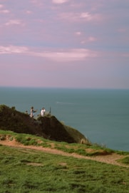 a couple of people sitting on top of a hill