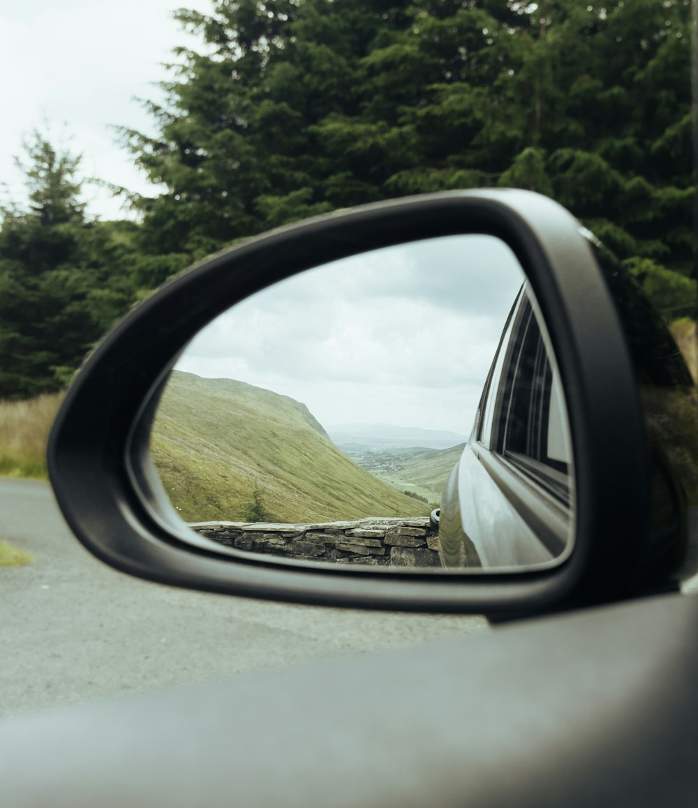 a car's side view mirror with a view of a mountain