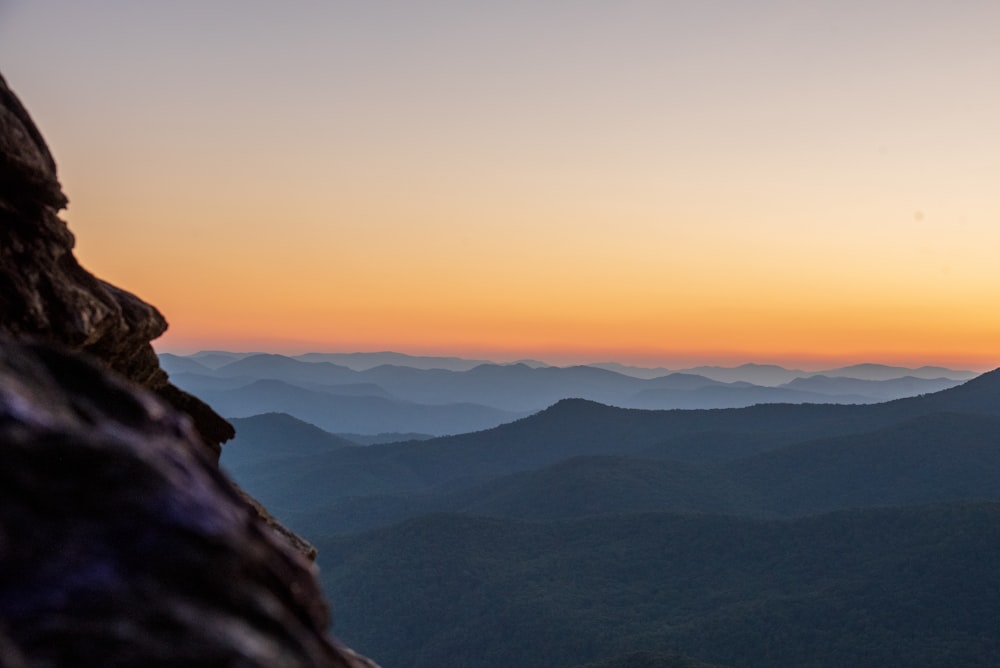 a person standing on top of a mountain at sunset