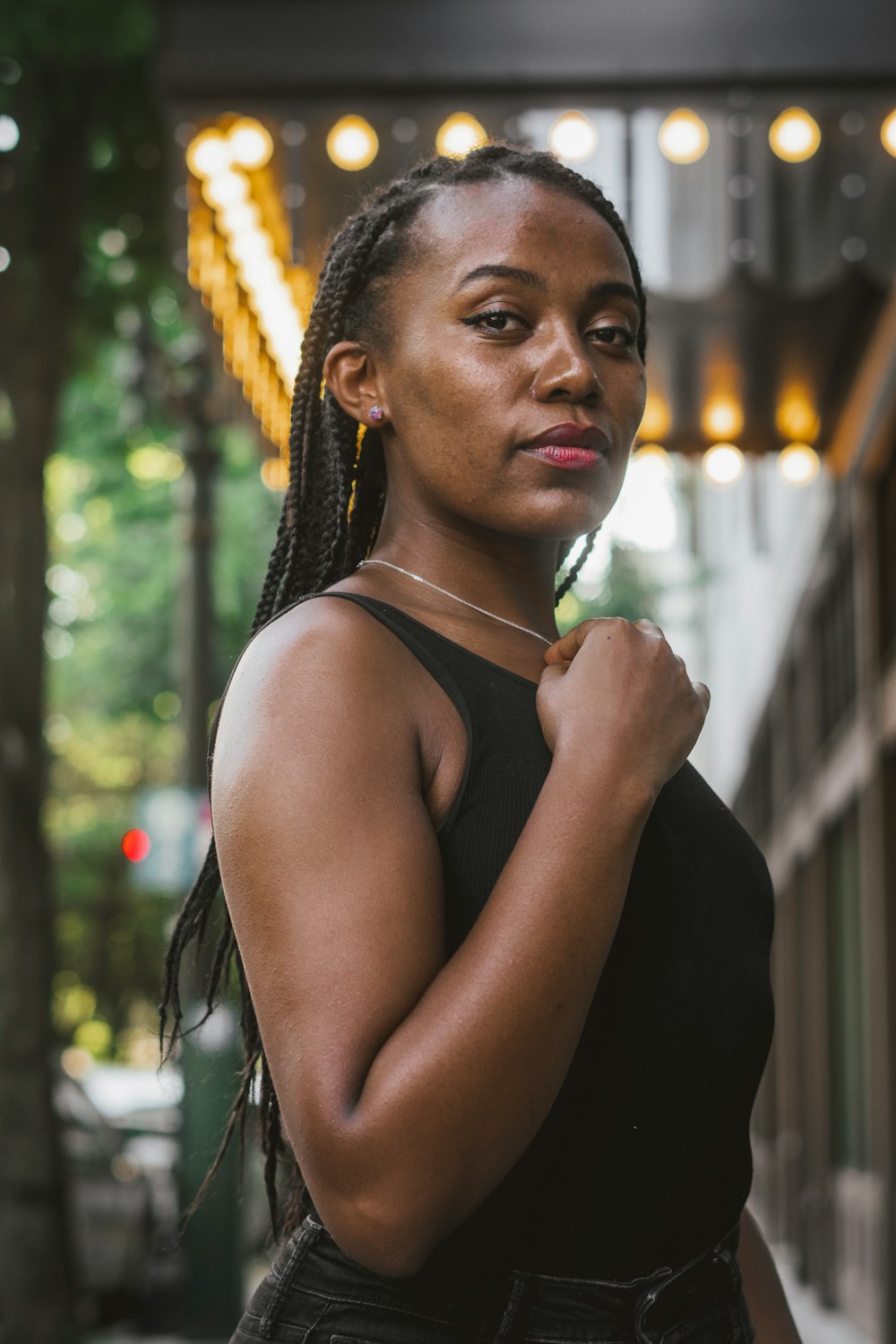 a woman with braids standing in front of a building