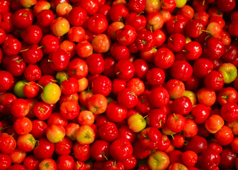 a pile of red cherries sitting next to each other