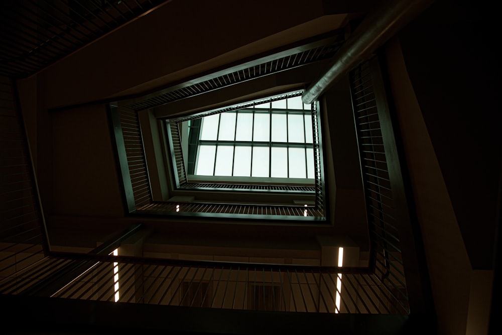 a view of a window from the bottom of a stairwell