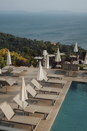 a group of lounge chairs sitting next to a swimming pool