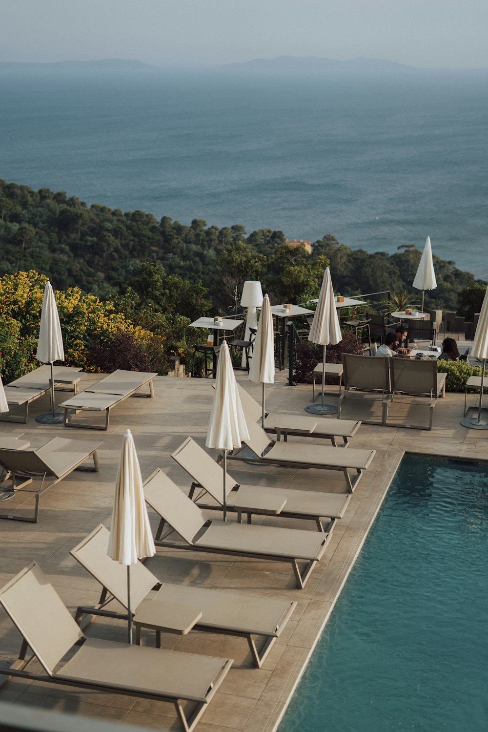 eine Gruppe von Liegestühlen, die neben einem Swimmingpool sitzen