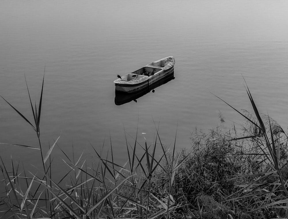 a small boat floating on top of a lake