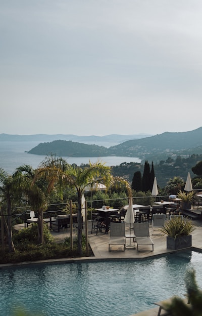 a large swimming pool next to a lush green hillside