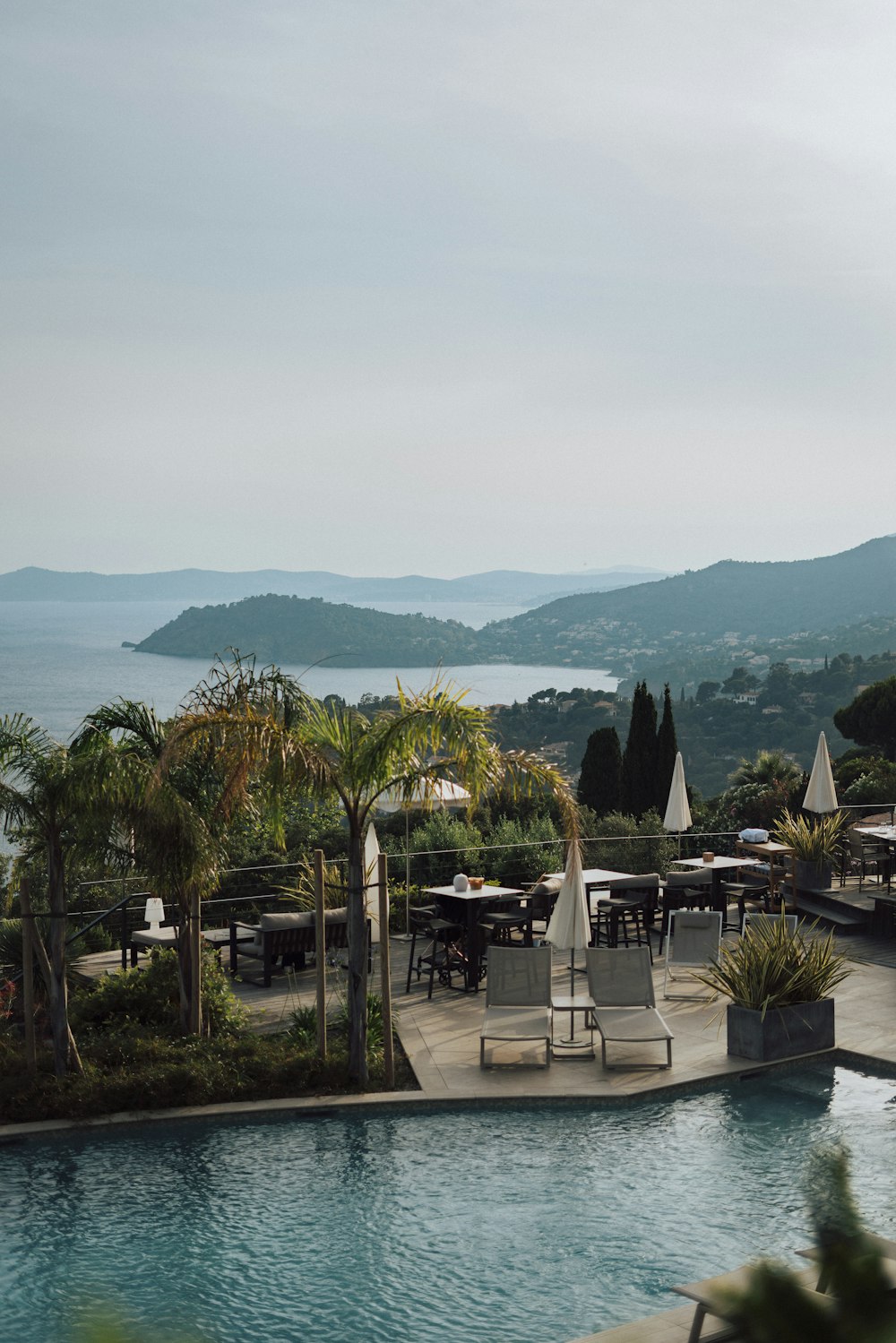 a large swimming pool next to a lush green hillside