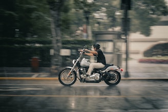 Rider wearing rain gear confidently cruising a wet city road on an electric bike