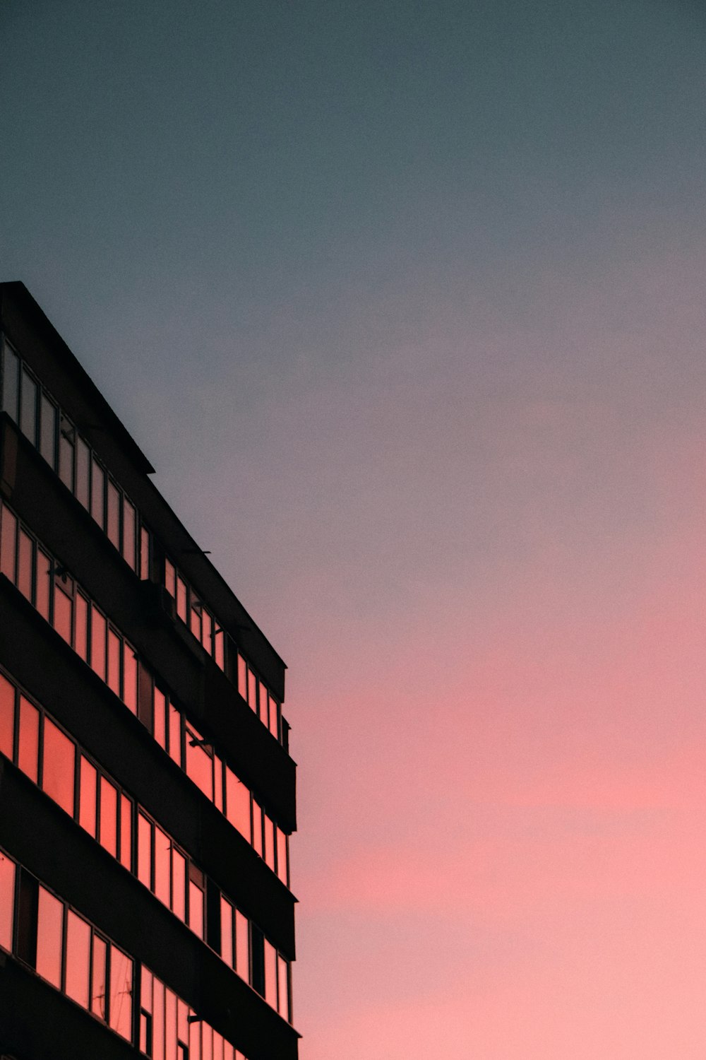 a tall building with many windows at sunset