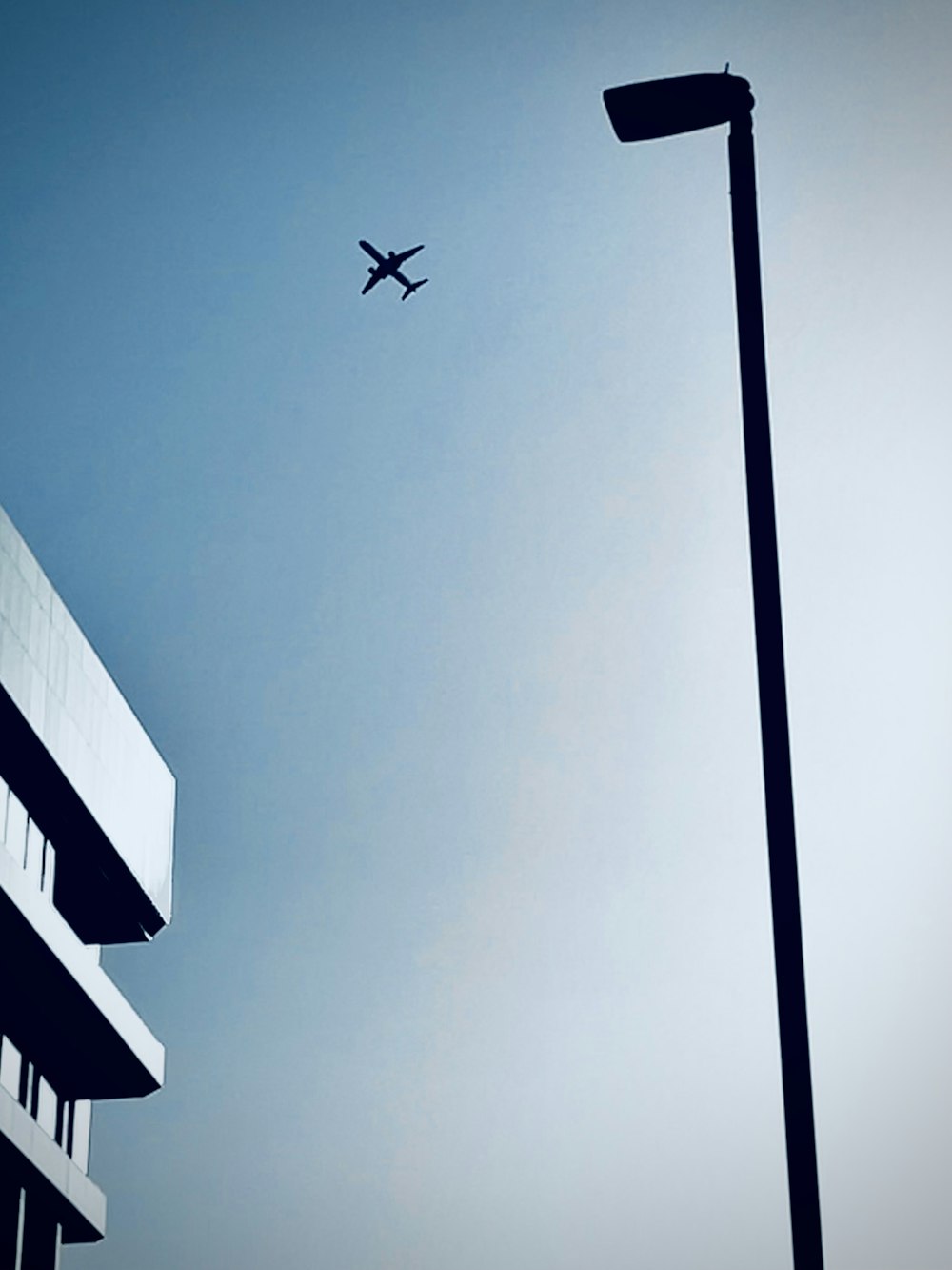 an airplane flying in the sky over a building