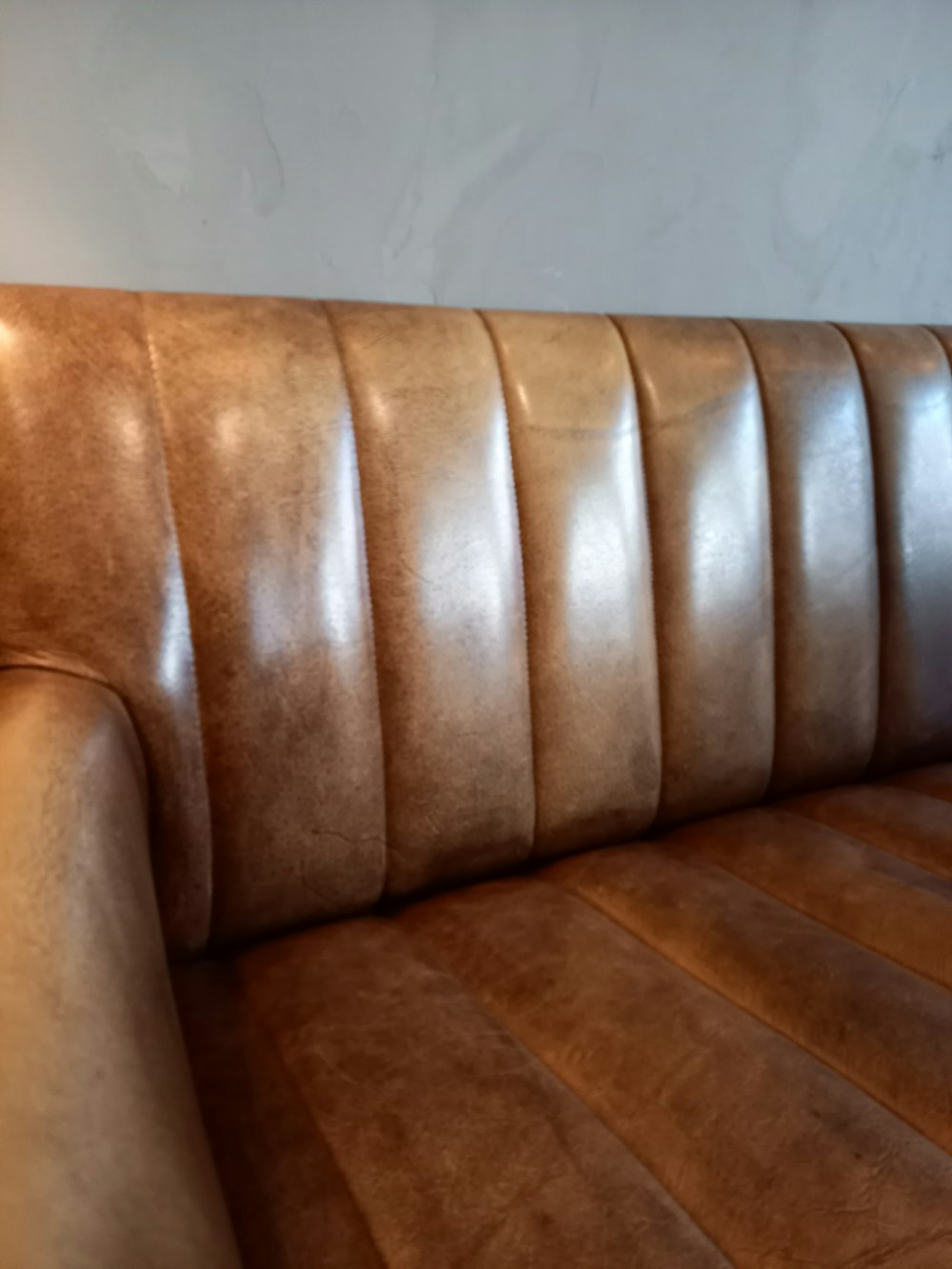 a brown leather couch with a white wall in the background
