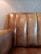 A close-up of a textured leather couch with vertical panels and a slightly worn appearance, set against a light-colored wall with subtle texture.