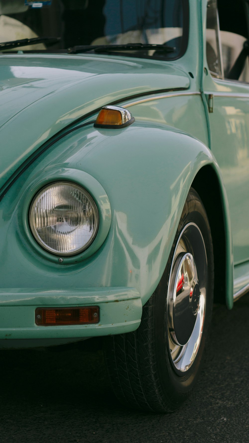 a close up of the front end of a green vw bug
