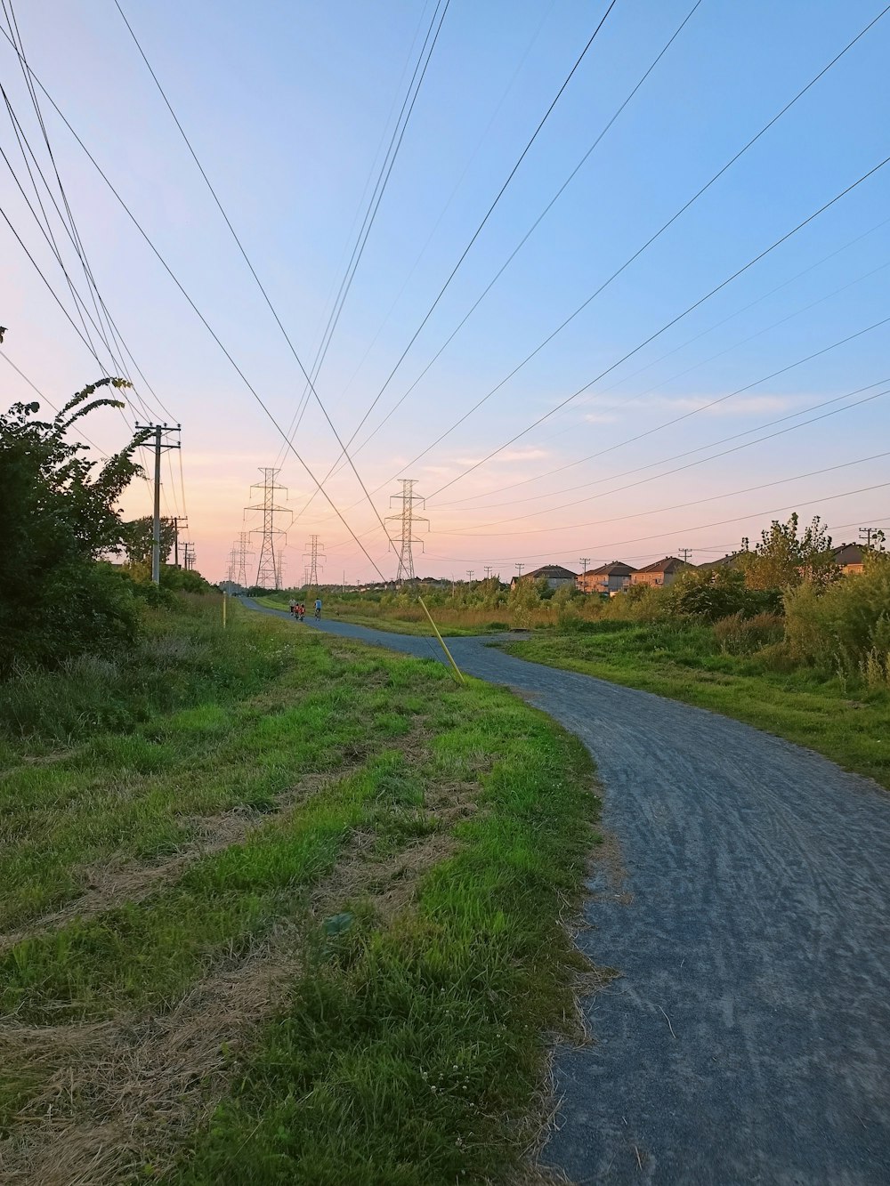 a rural road with power lines above it