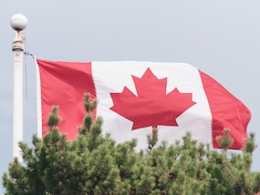 a canadian flag is flying in the wind