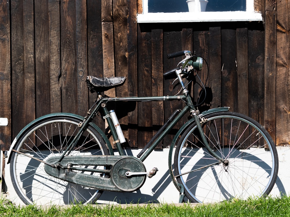 a bicycle parked next to a wooden fence