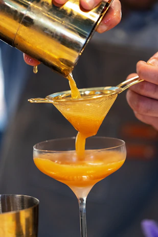 An instructor demonstrating the perfect shake technique with a gleaming cocktail shaker.