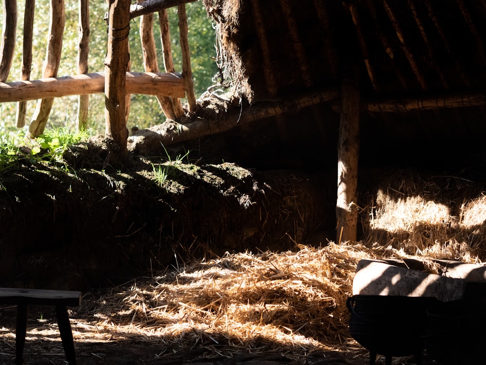 a wooden bench sitting next to a pile of hay