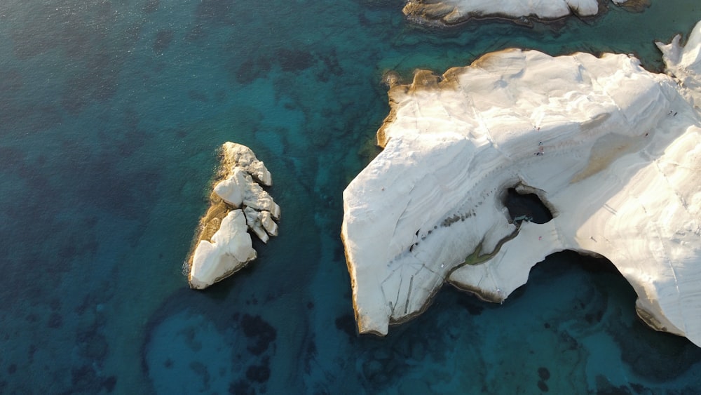 an aerial view of some rocks in the water