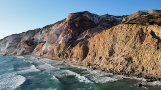 a view of a rocky cliff next to the ocean