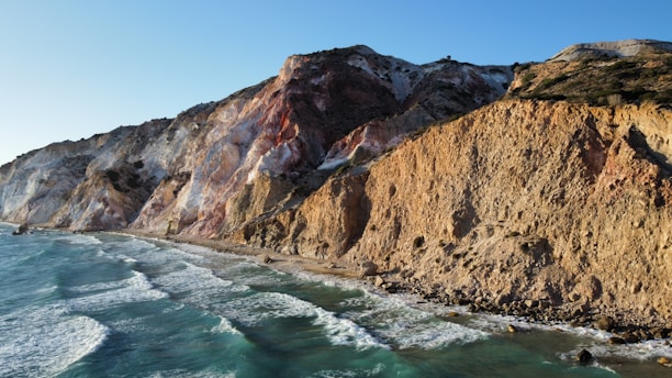 a view of a rocky cliff next to the ocean