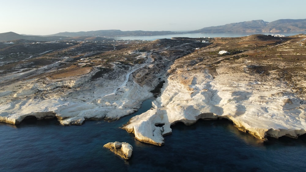 an aerial view of a rocky coastline with a body of water