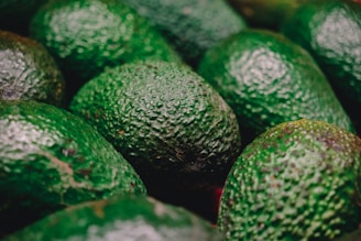 a pile of green avocados sitting next to each other