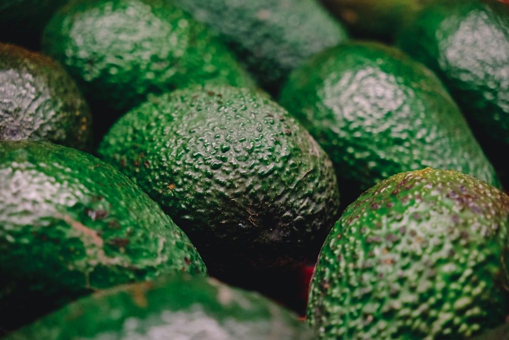 a pile of green avocados sitting next to each other