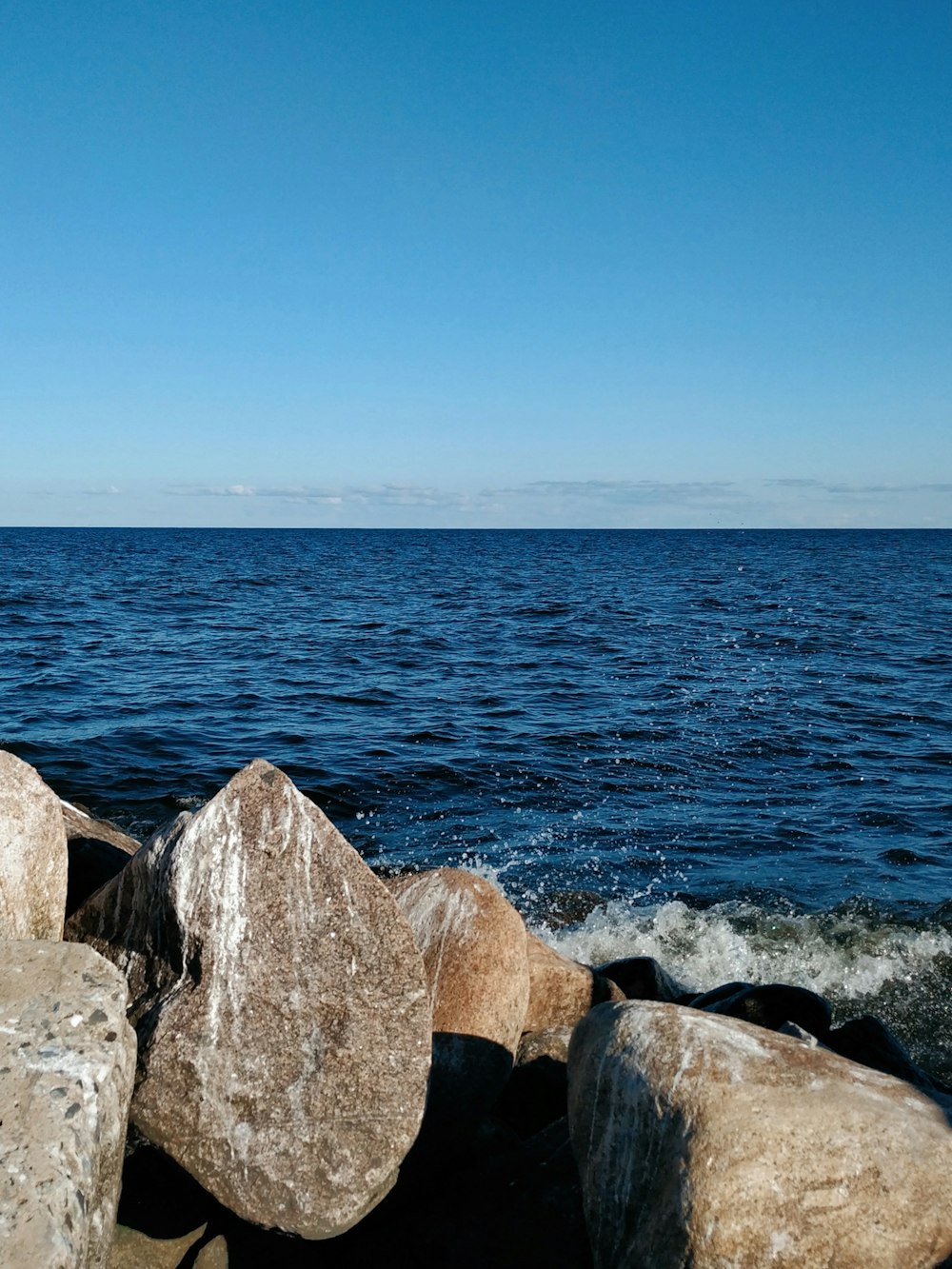 a large body of water sitting next to a rocky shore