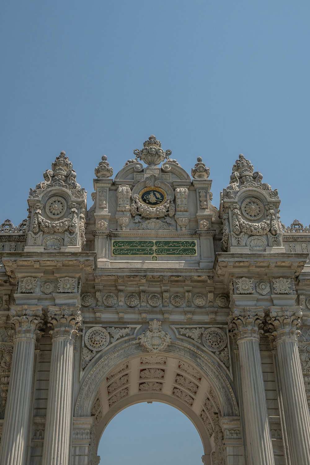 un grande arco di pietra con un orologio in cima