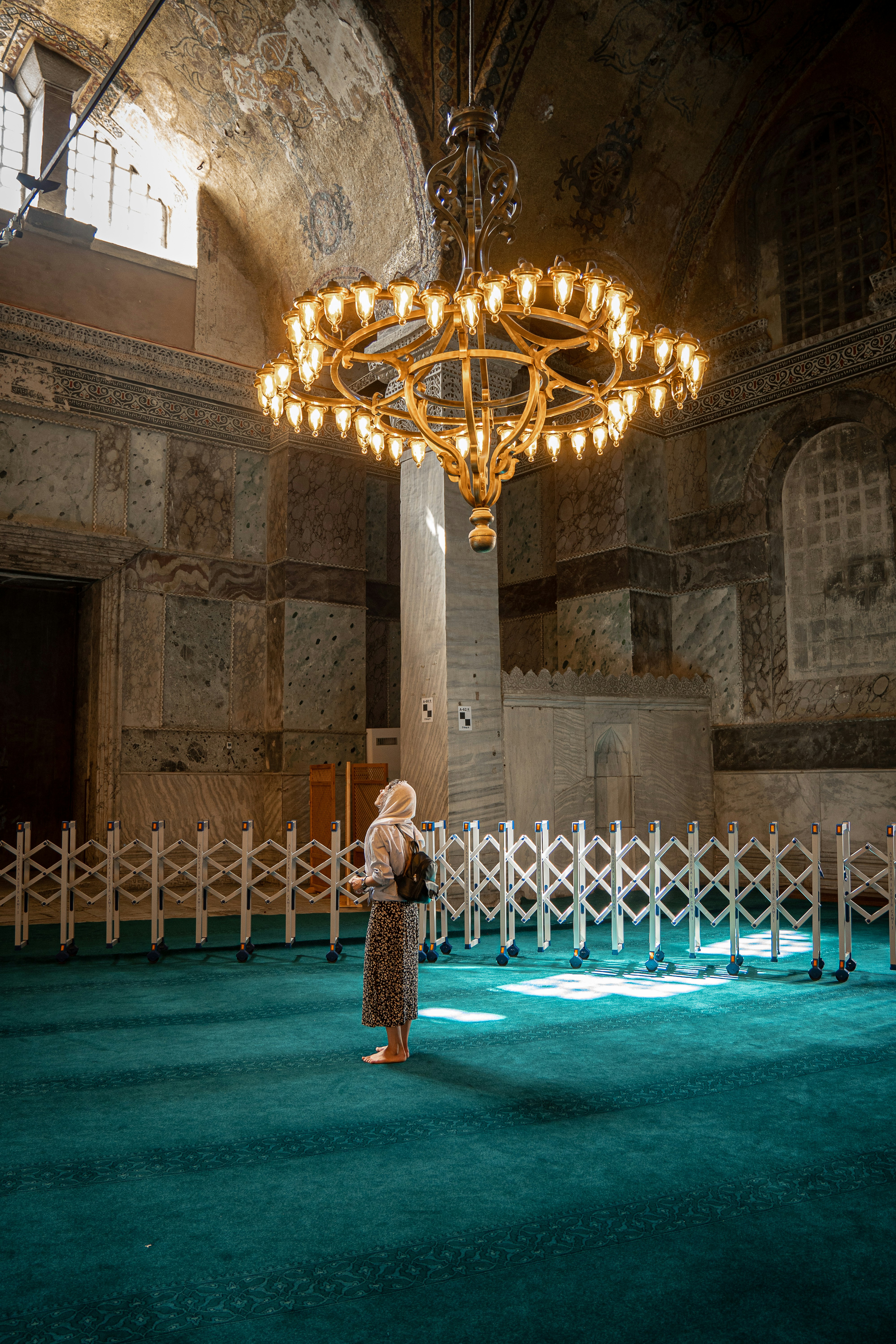 a person standing in a room with a chandelier