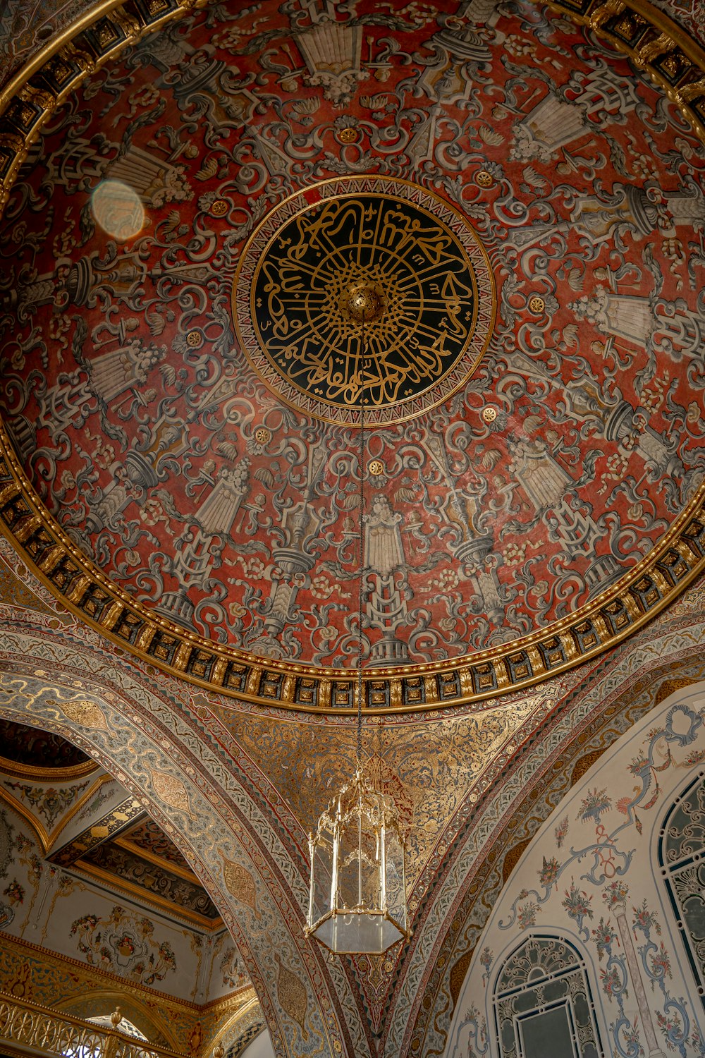 an ornate ceiling with a chandelier hanging from it