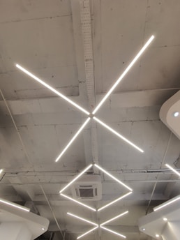 A sleek, modern LED lighting fixture installed in a spacious industrial warehouse, casting bright, even light.